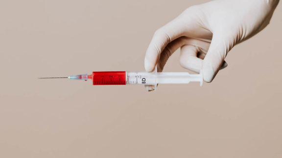 A syringe filled with a red fluid.