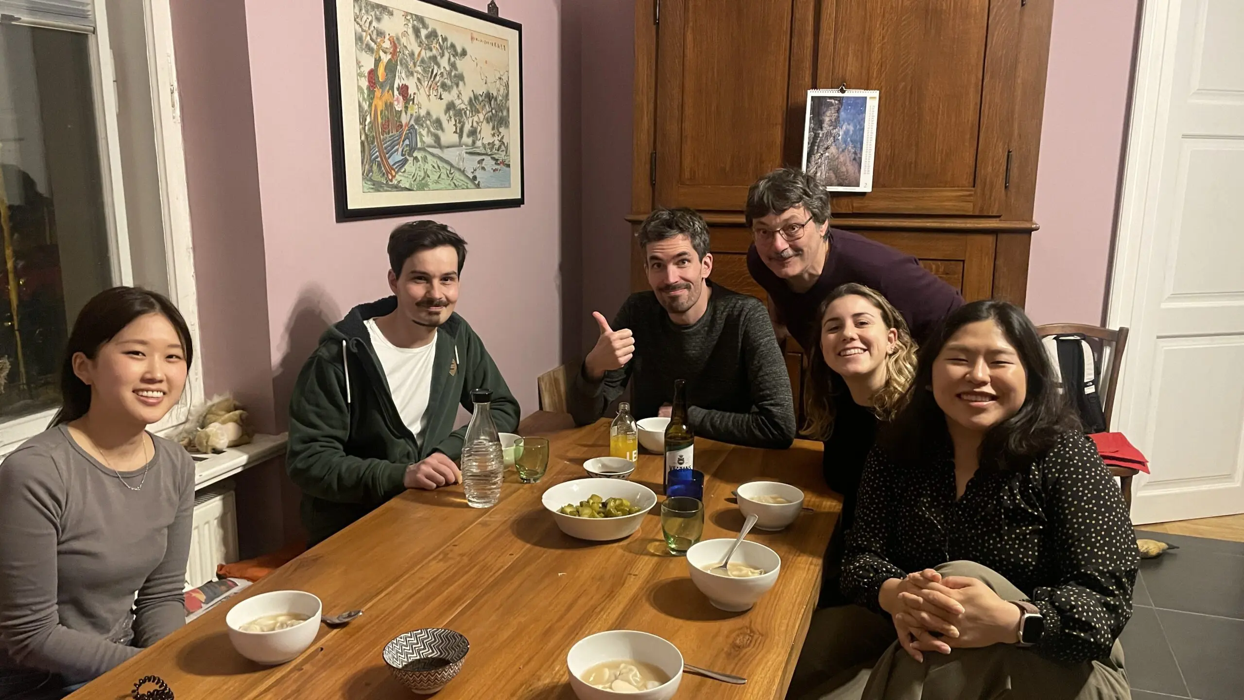 people gathered around a wooden table for a meal